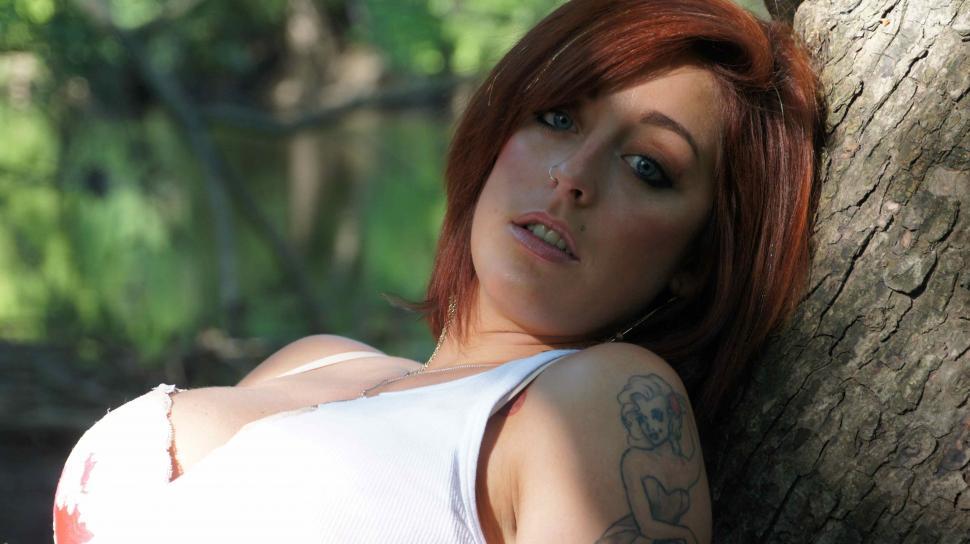 Free Image of Woman Poses Against Tree 