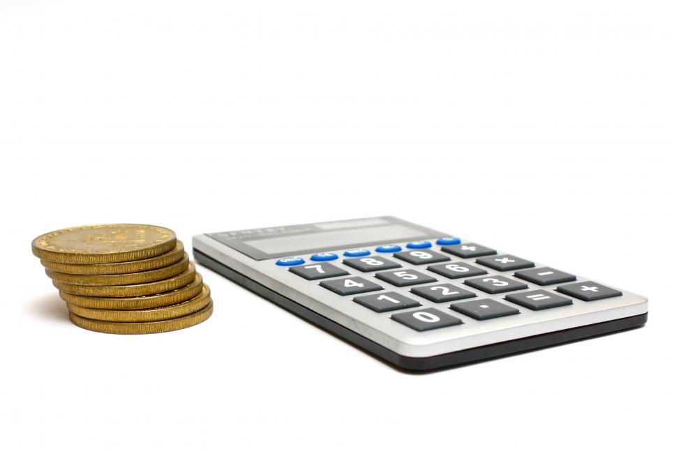 Free Stock Photo of A calculator and a stack of gold coins