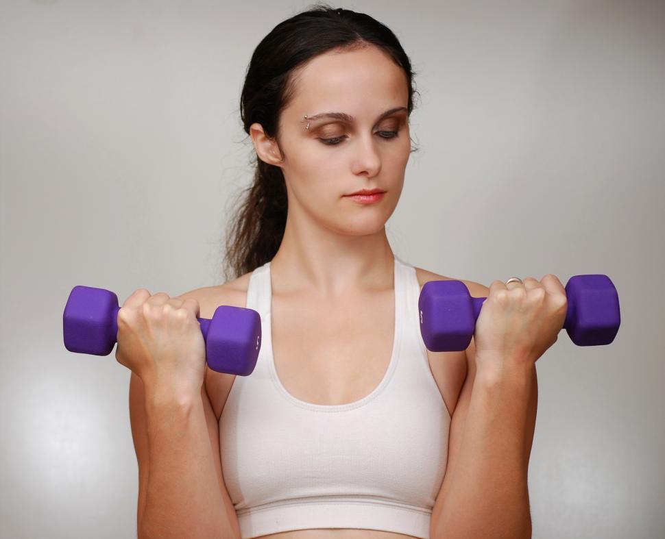 Free Stock Photo of A beautiful young woman exercising with weights