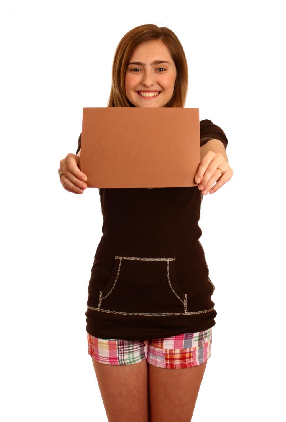 Free Image of A cute young girl posing with a blank brown sign 