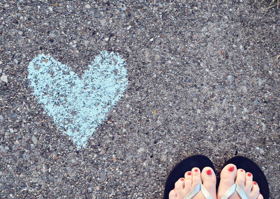 Free Image of Person Standing on Sidewalk With Heart Drawing 