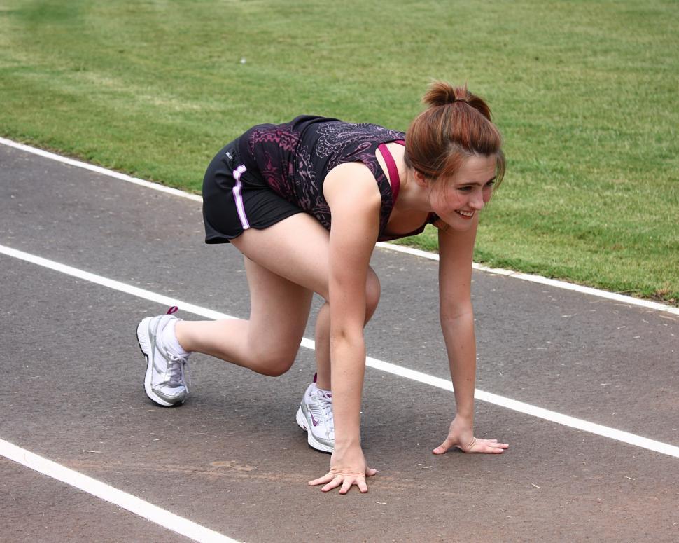 Free Stock Photo of A cute young girl on a track field preparing