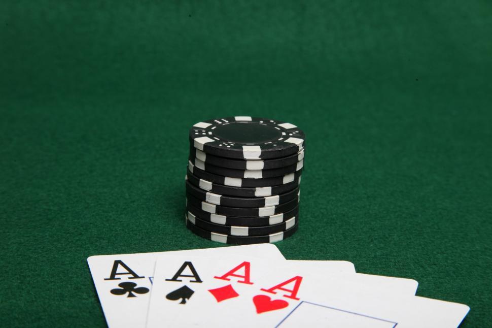 Black poker chips and 4 aces