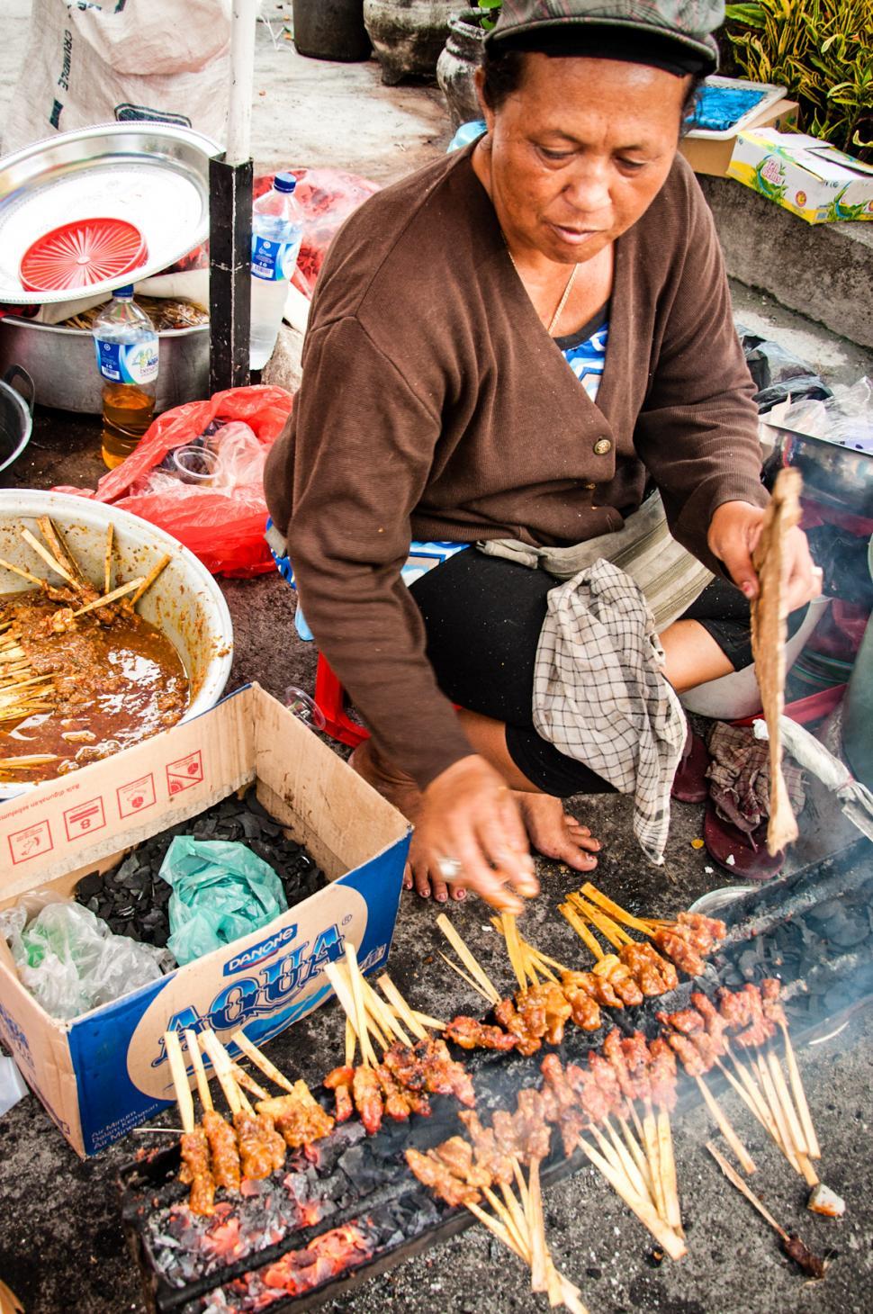 Asian woman selling sate on the street