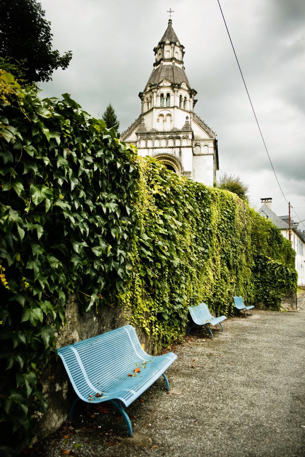 Free Image of Park benches by historical church 