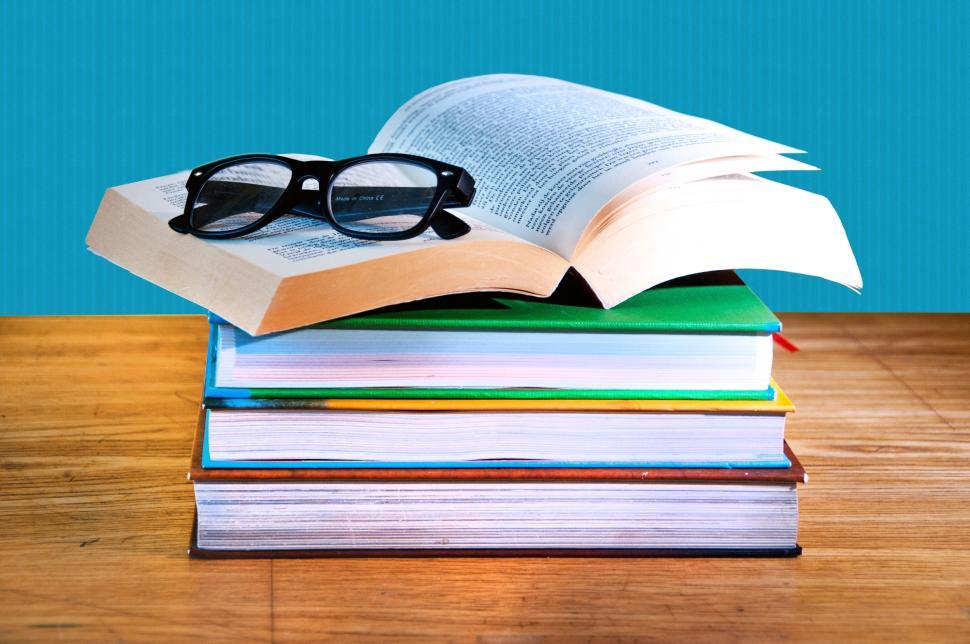 Free Image of stack of books with a pair of eyeglasses 
