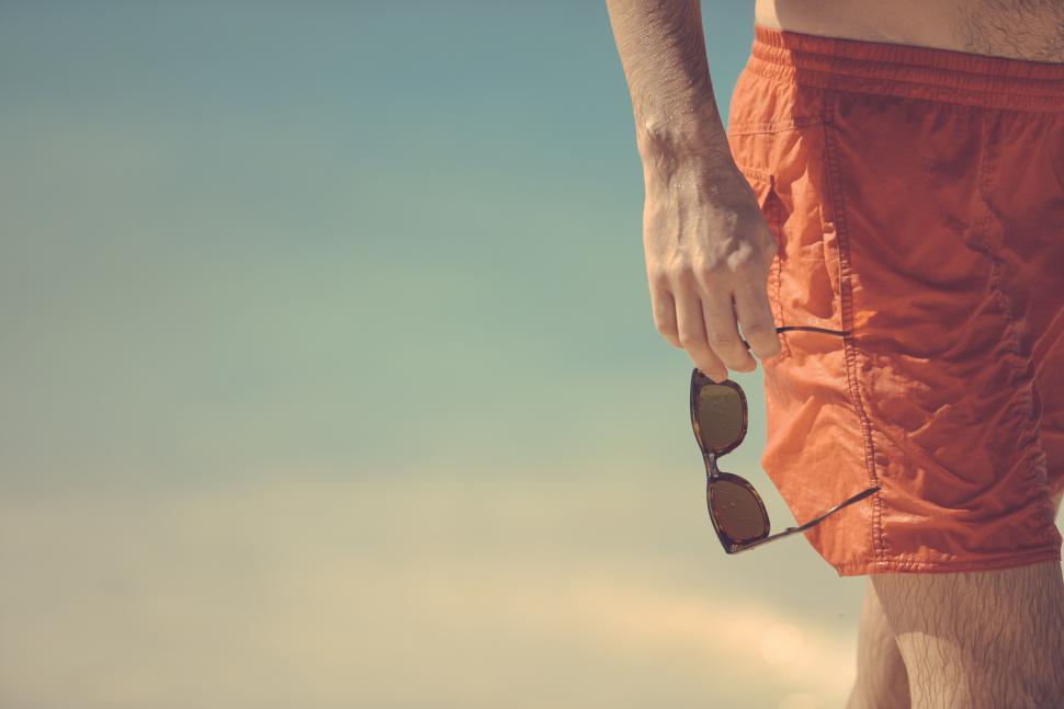 Free Image of Man holds sunglasses 