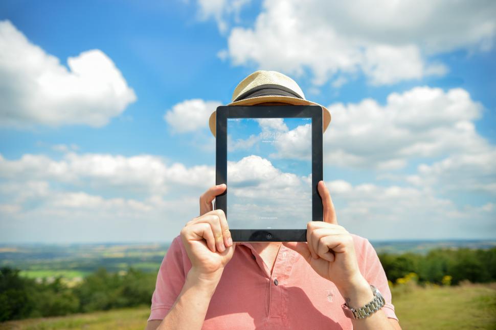 Free Image of Tablet showing sky over face 