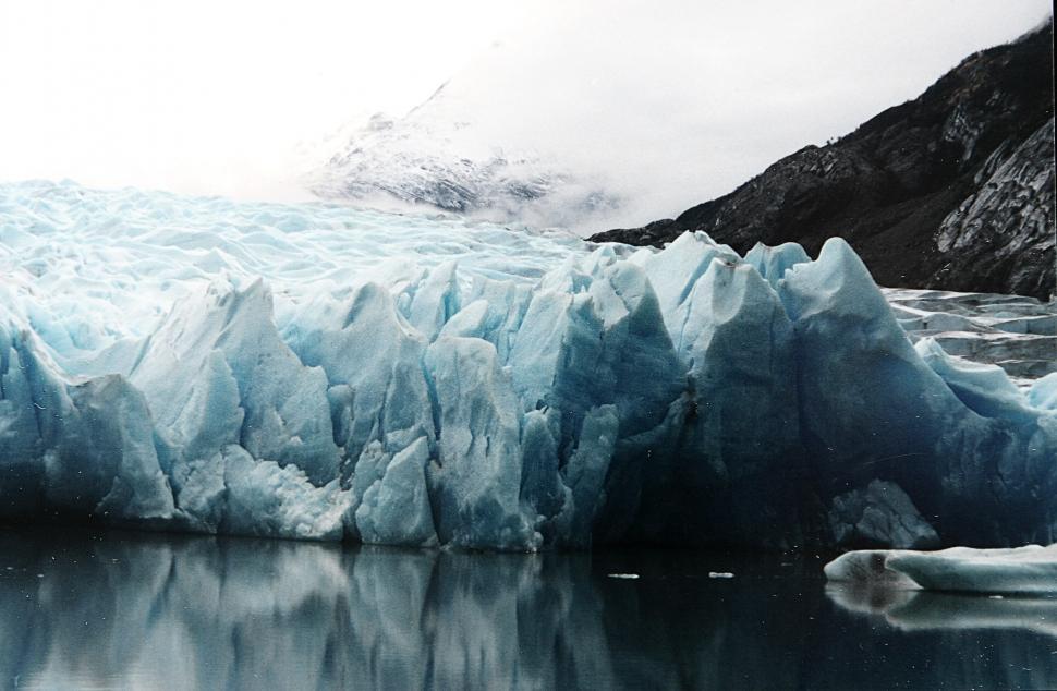 Free Image of Massive Iceberg Drifting by Snow-covered Mountain 