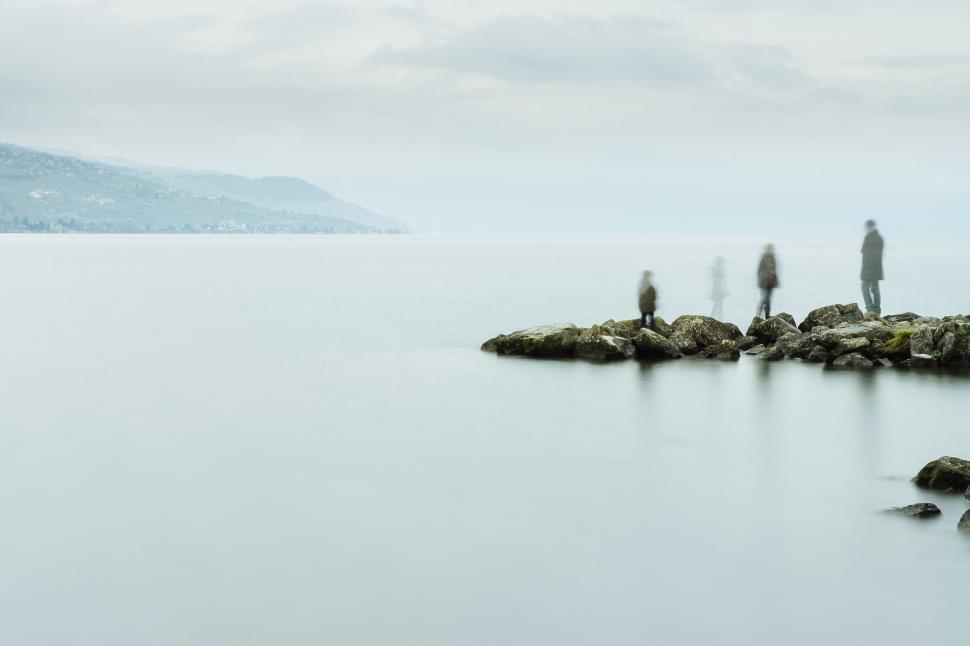 Free Image of Group of People Standing on Rocky Shore 