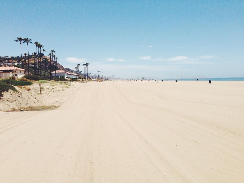Free Image of Sandy Beach With Houses and Palm Trees 