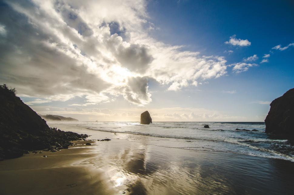 Free Image of Sun Shines Through Clouds Over Ocean 