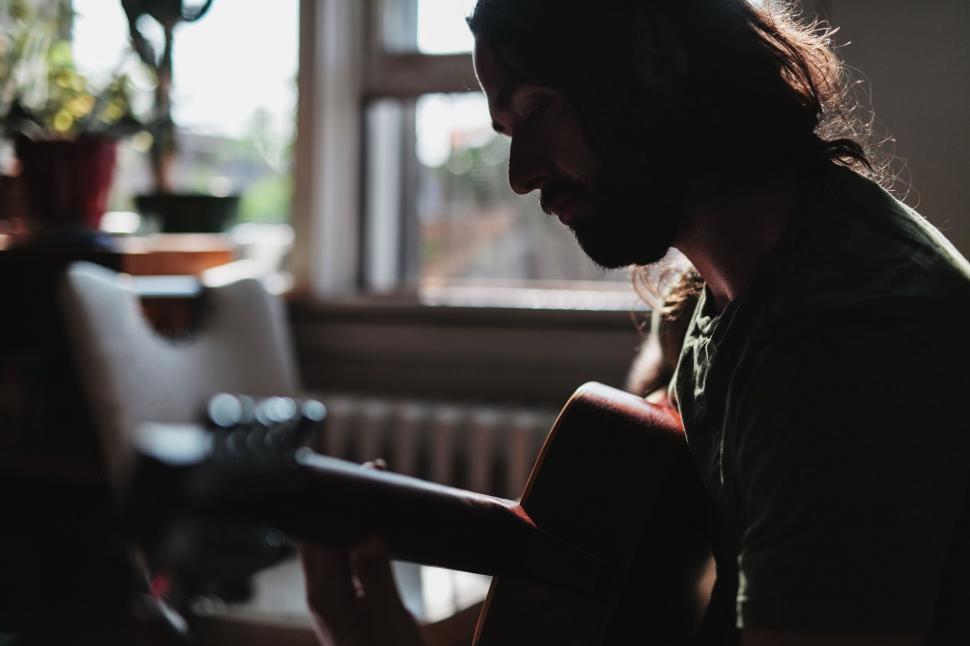 Free Image of Man Playing Guitar With Long Hair 