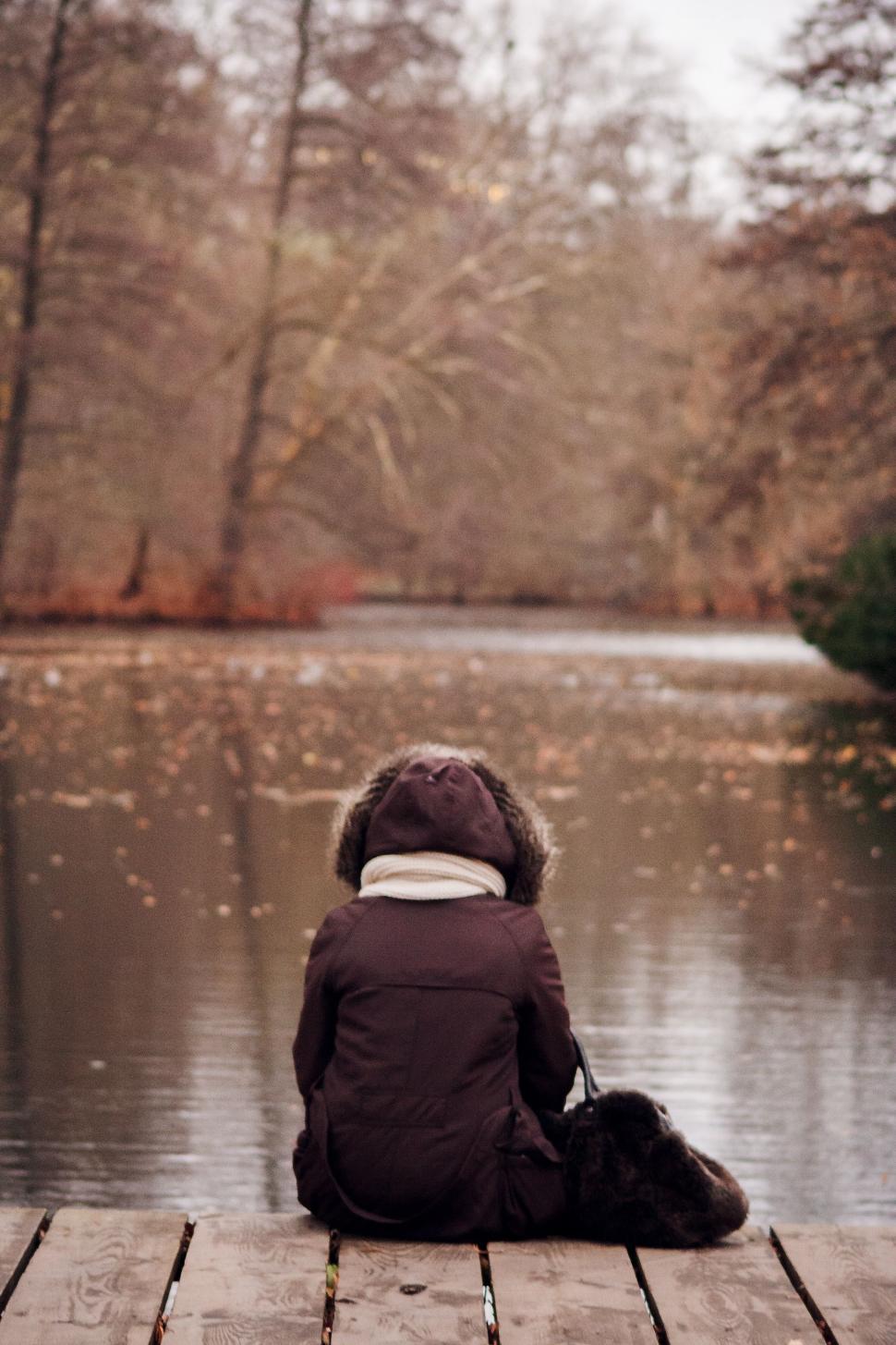 Free Image of Person Sitting on Dock, Contemplating Water 