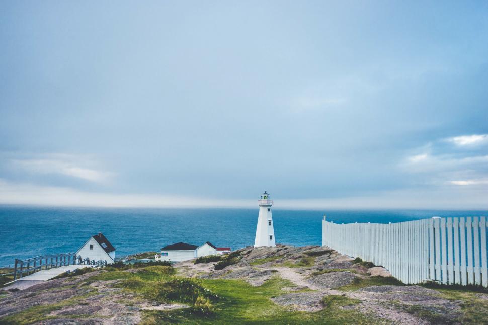 Free Image of Lighthouse Overlooking Hill by Ocean 
