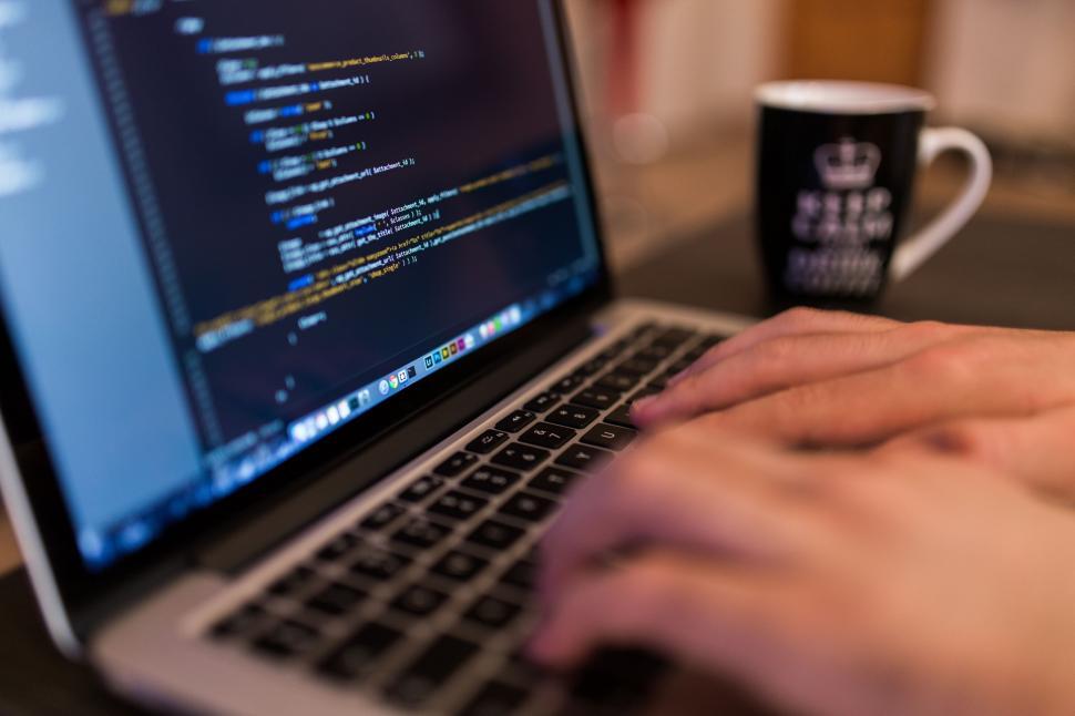Free Image of Person Typing on Laptop With Coffee Mug 
