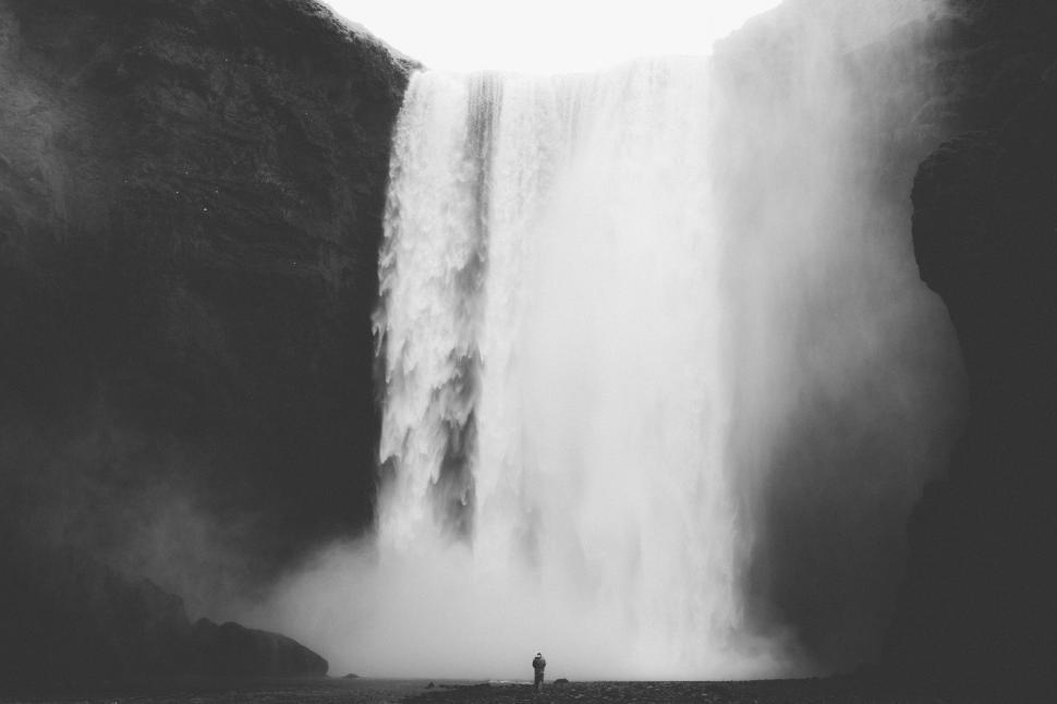 Free Image of Man Standing in Front of Waterfall 