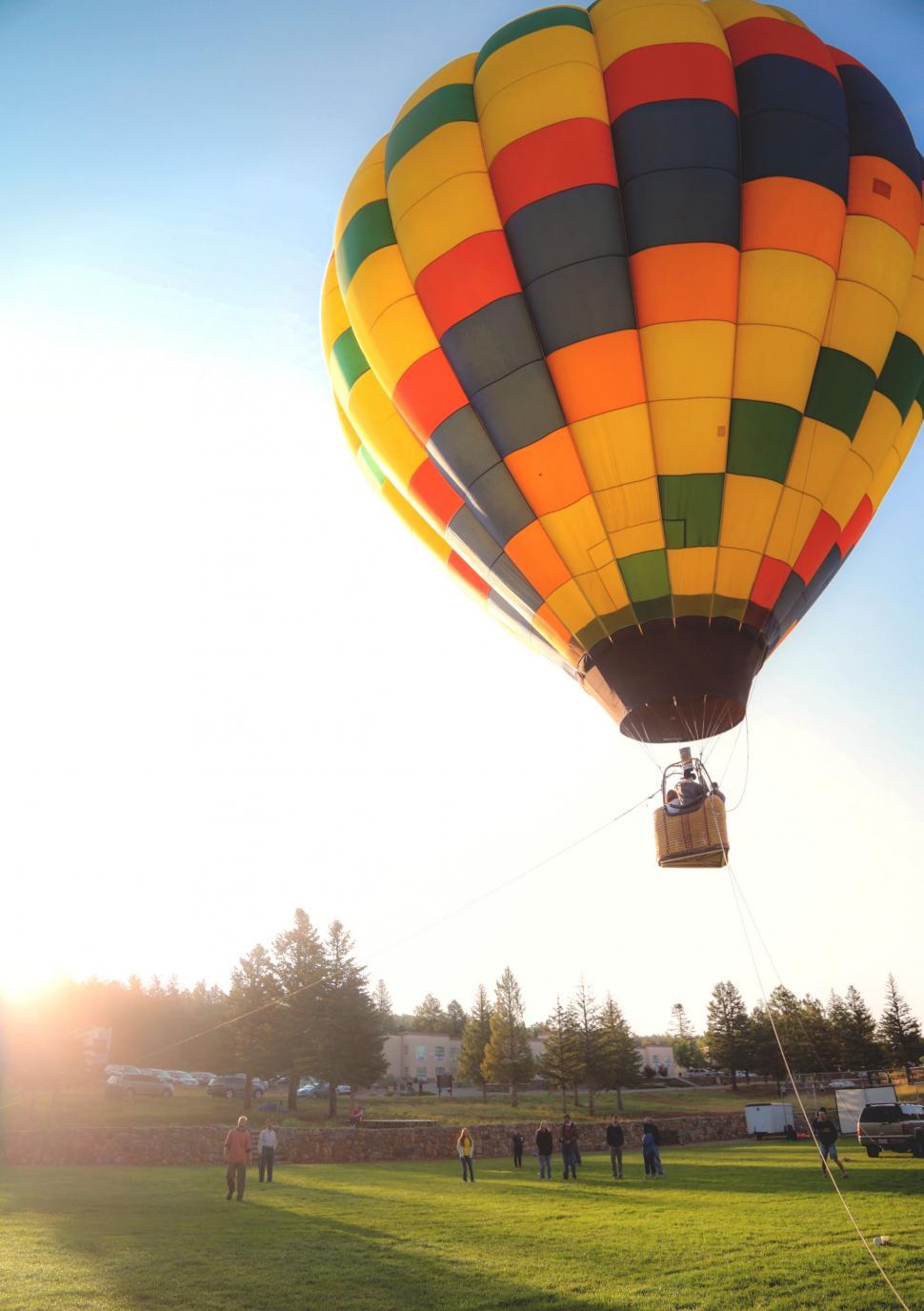 Free Image of Hot Air Balloon Flying Over Lush Green Field 
