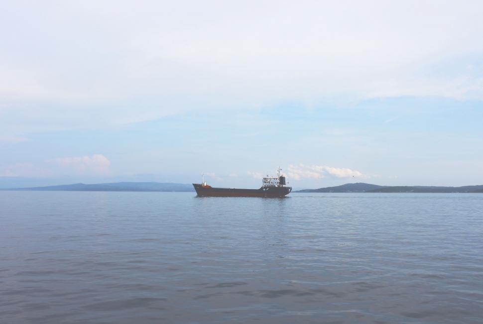 Free Image of Boat Navigating Through Vast Body of Water 