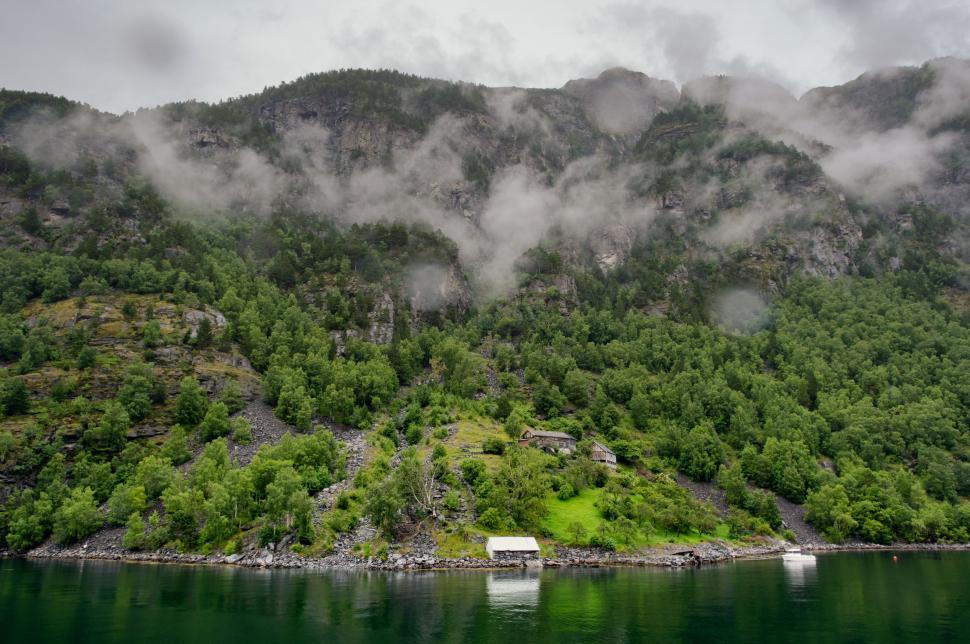 Free Image of Boat Floating on Lake Surrounded by Mountains 