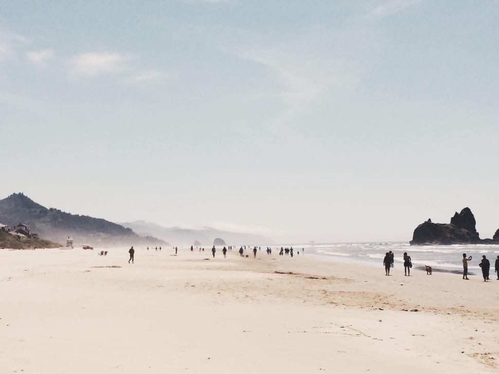 Free Image of Group of People Standing on Top of Sandy Beach 