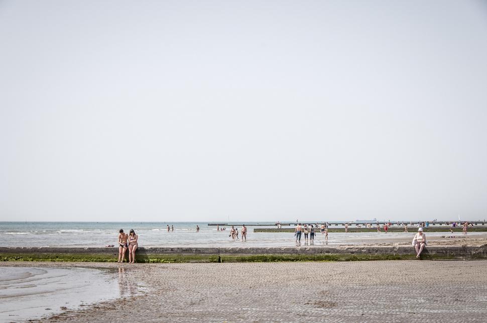 Free Image of Group of People Standing on Top of a Sandy Beach 