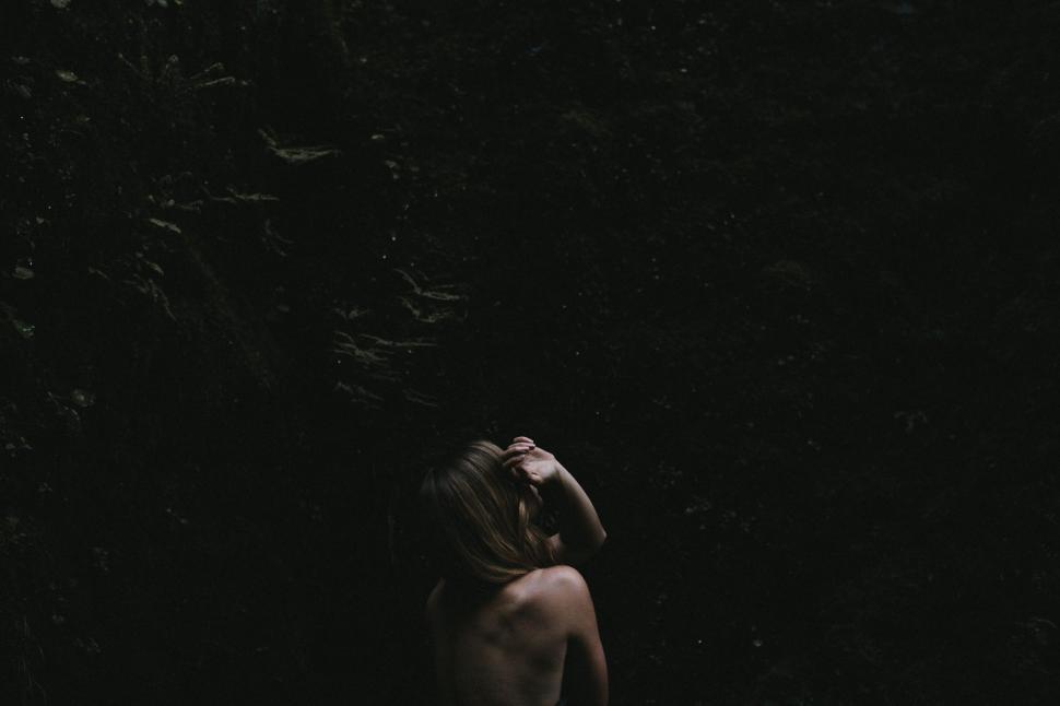 Free Image of Woman Standing in the Dark With Head in Hands 