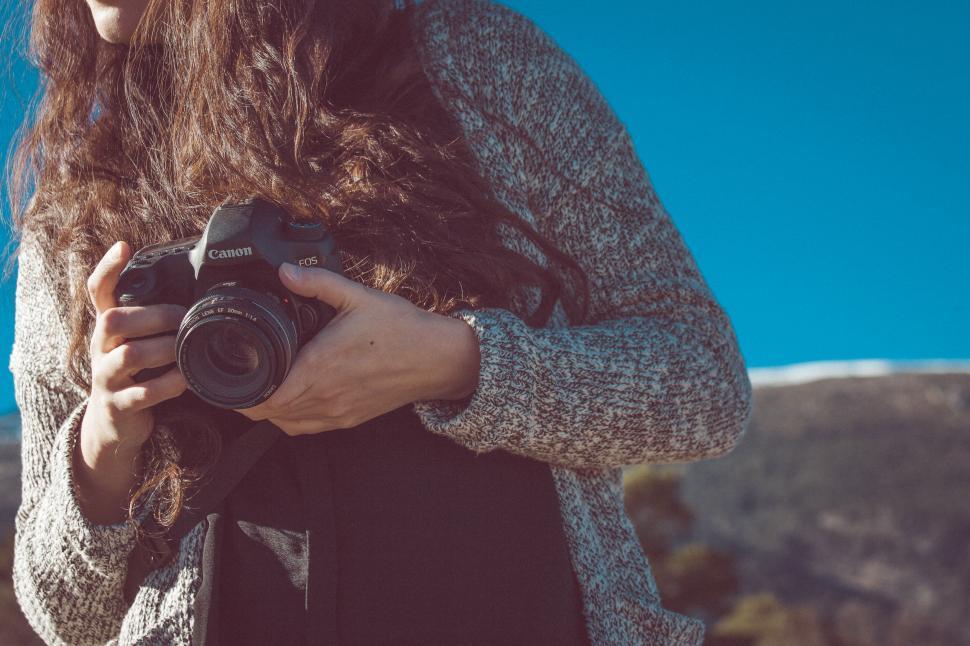 Free Image of Woman With Long Hair Holding a Camera 