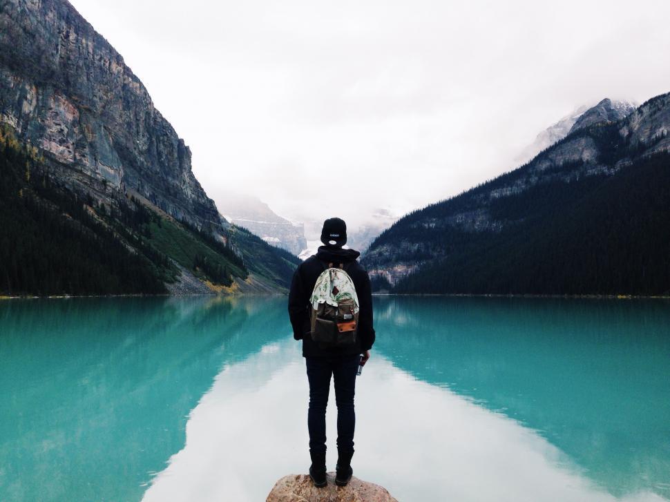 Free Image of Person Standing on Rock by Lake 