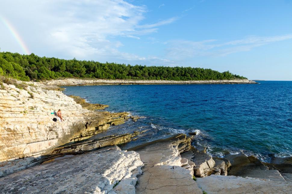 Free Image of Rainbow Over Rocky Shoreline 