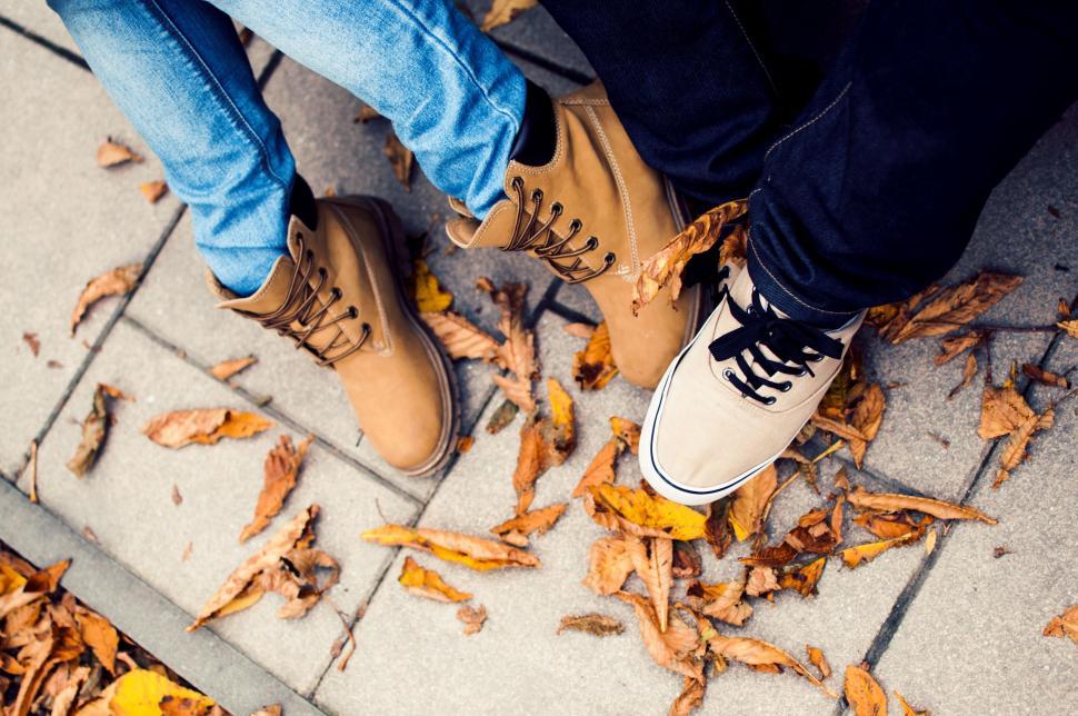 Free Image of Person Standing on Sidewalk With Pair of Shoes 