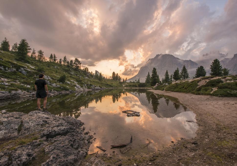 Free Image of Man Standing on Rocky Shore by Lake 