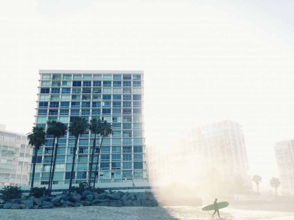 Free Image of Man Standing on Beach With Surfboard 