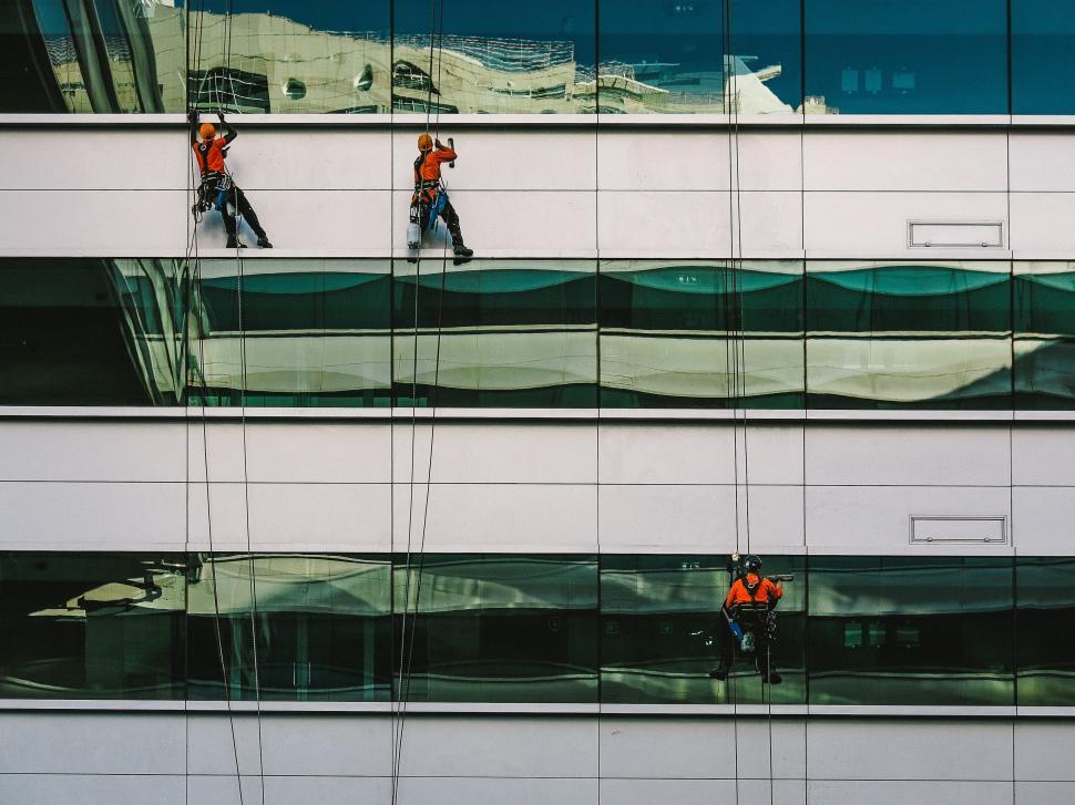 Free Image of Group of People Walking Next to Tall Building 