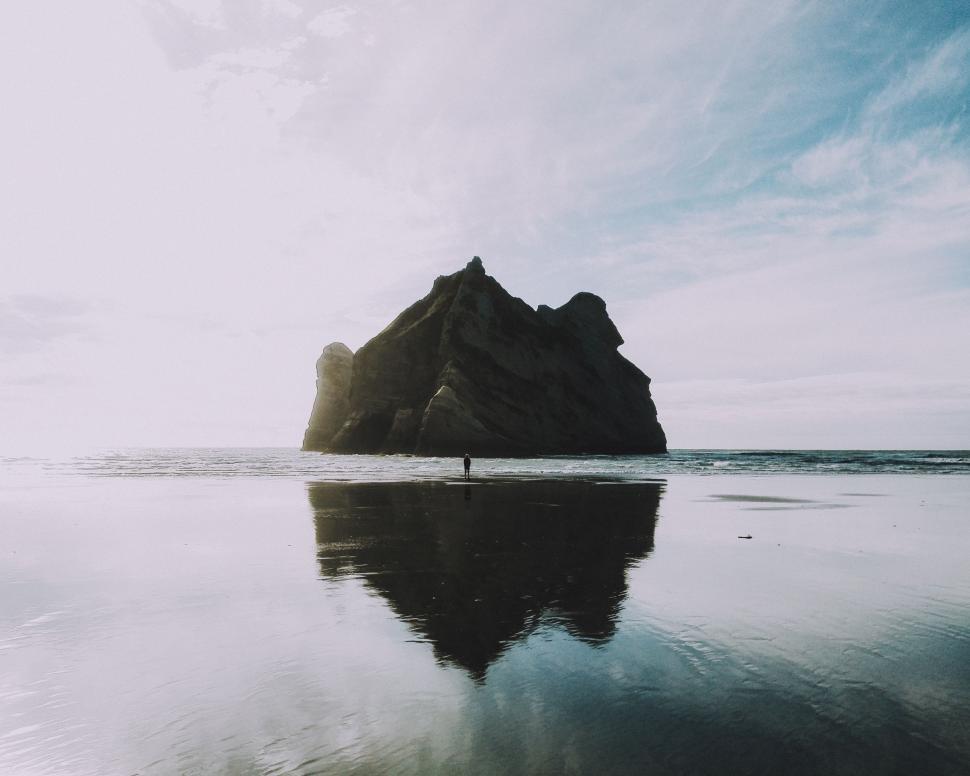 Free Image of Large Rock in the Middle of a Body of Water 