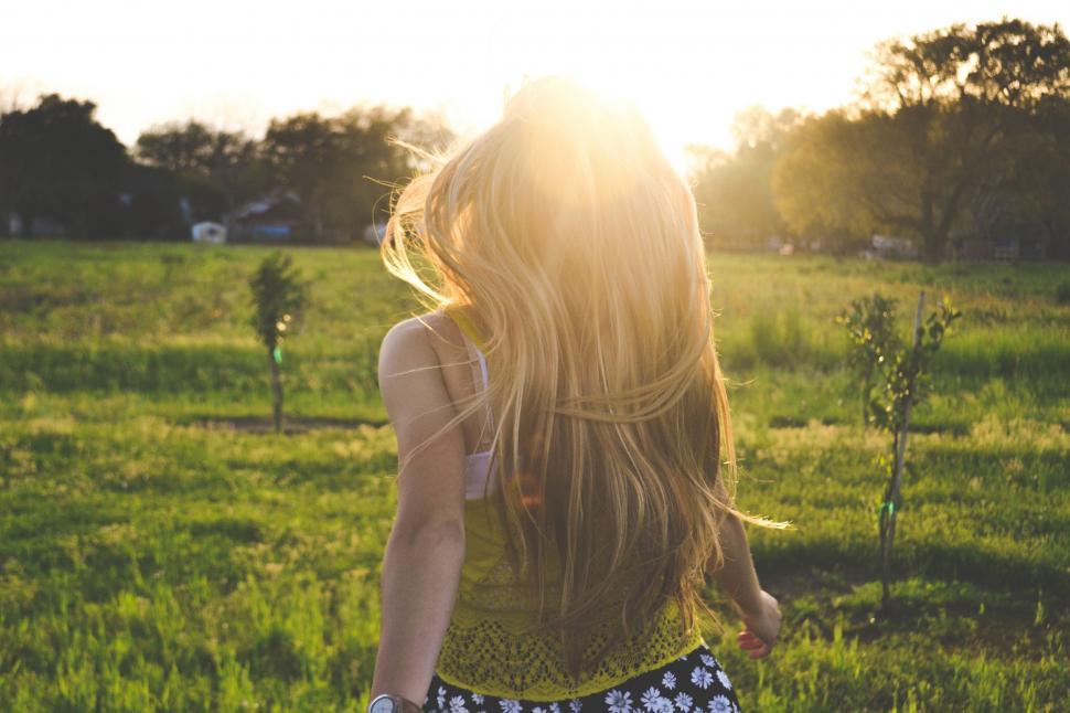 Free Image of Woman Walking Through Lush Green Field 