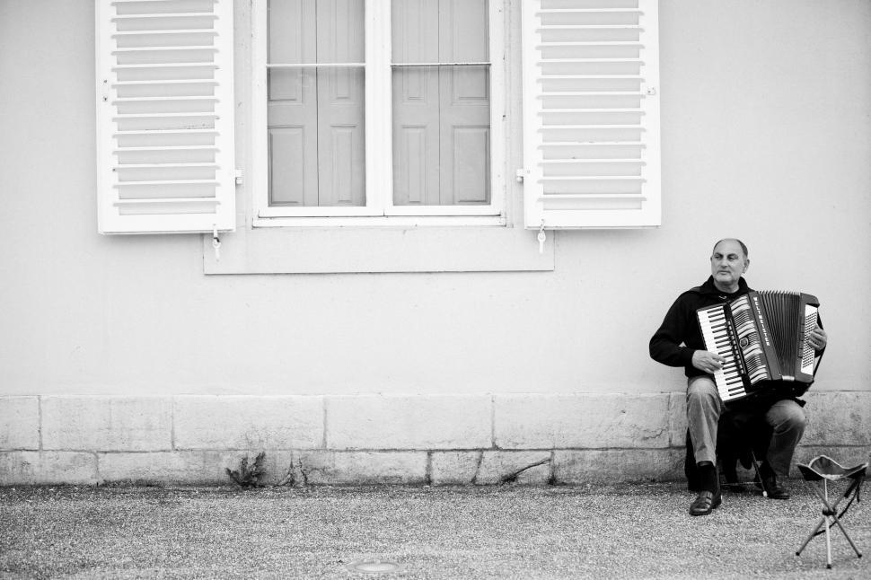 Free Image of Man Playing Accordion in Front of Building 