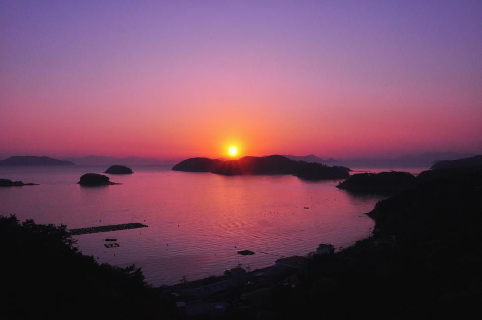 Free Image of The Sun Setting Over a Body of Water 