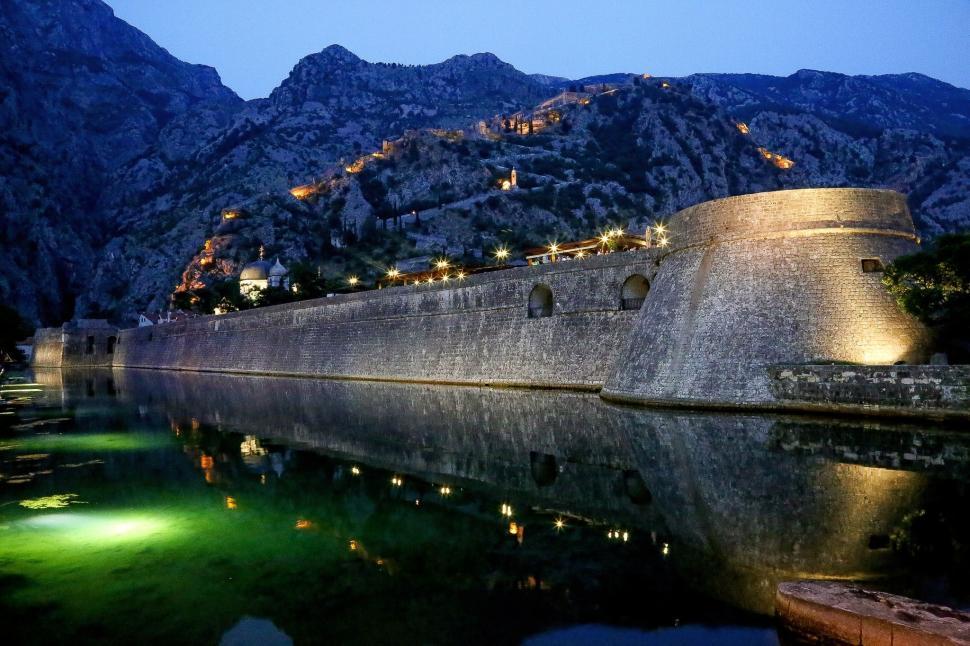 Free Image of Large Stone Wall Next to Body of Water 