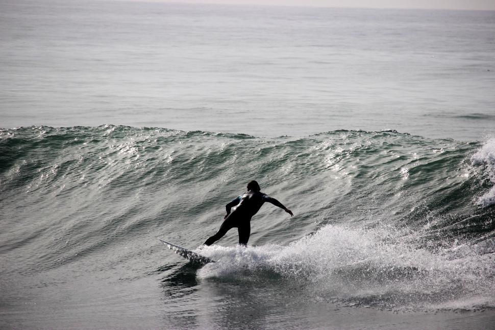 Free Image of Man Riding Wave on Surfboard 