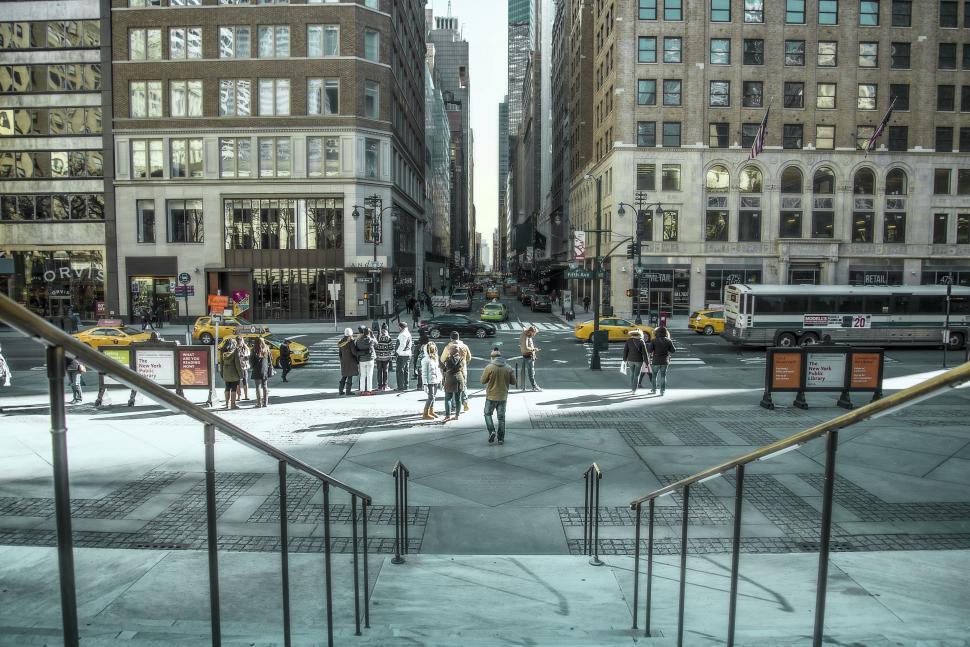 Free Image of Group of People Walking Down a Street Next to Tall Buildings 