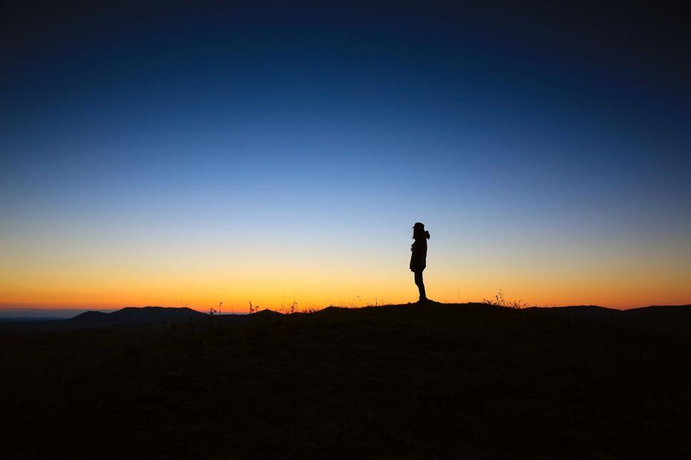 Free Image of Person Standing on Top of Hill at Sunset 