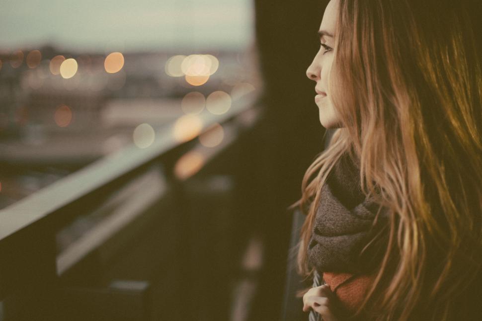 Free Image of Woman Looking Out Over City at Night 