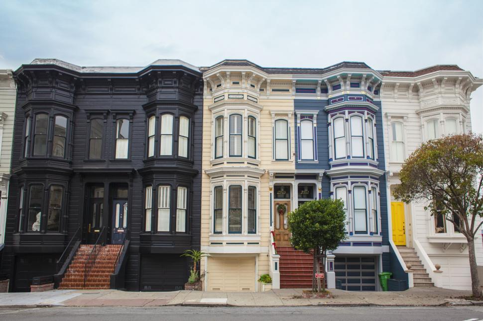 Free Image of A Row of Multi-Colored Houses on a Street Corner 