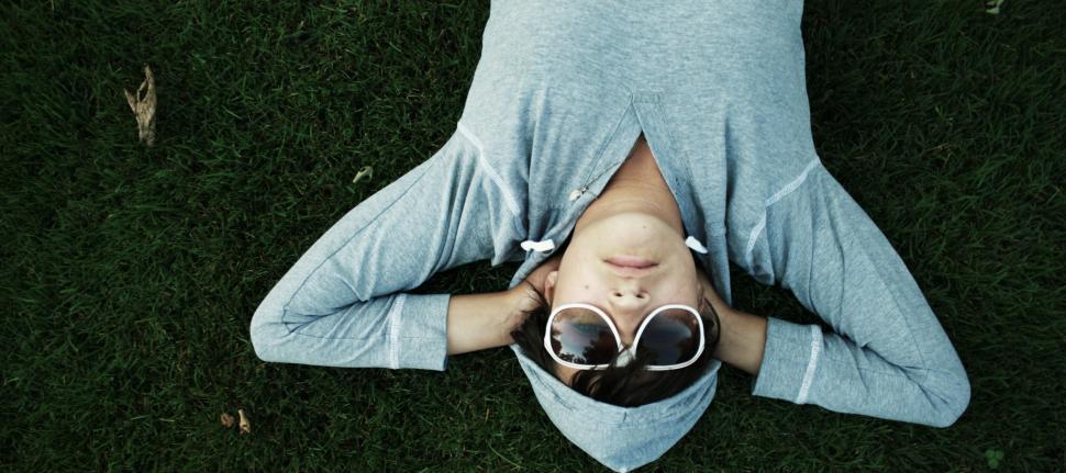 Free Image of Man Laying on Grass With Head in Hands 