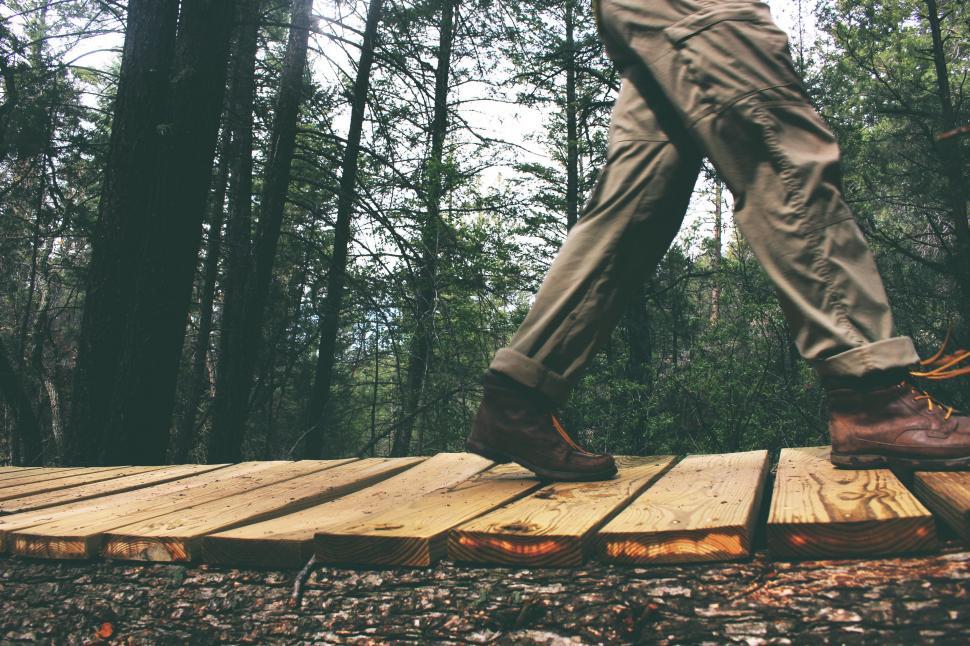 Free Image of Man Walking Across Wooden Bridge in Woods 