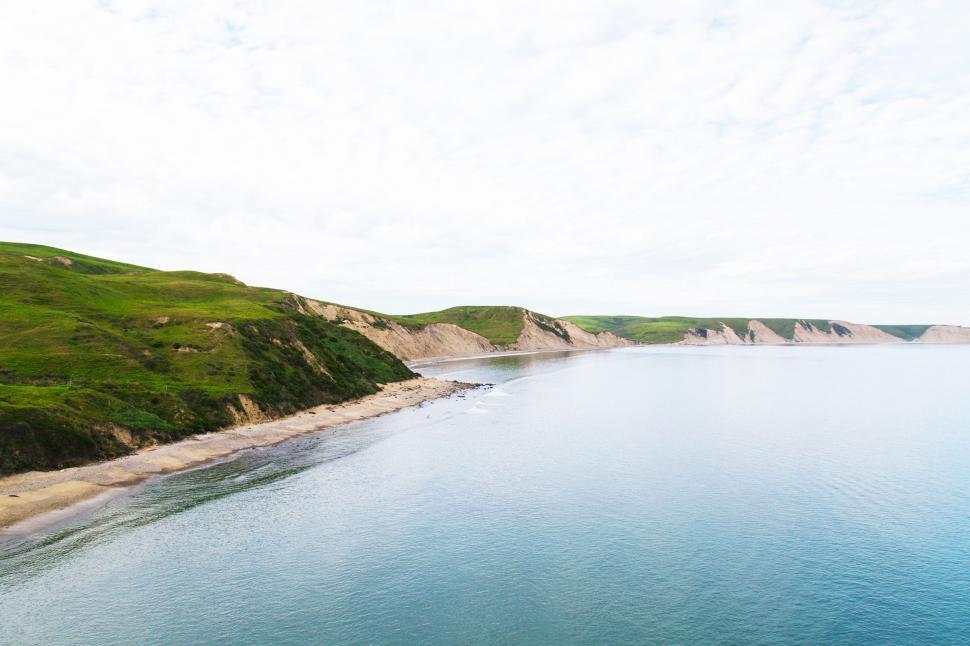 Free Image of Majestic Body of Water Surrounded by Green Hills 