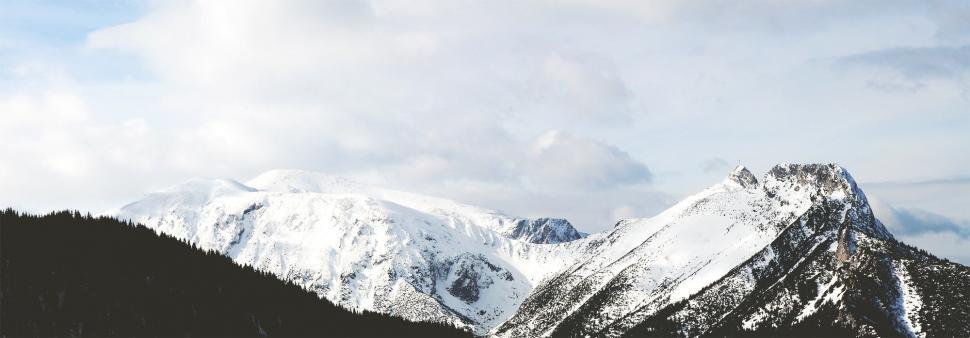 Free Image of Cloudy Sky Over Snow Covered Mountain Range 