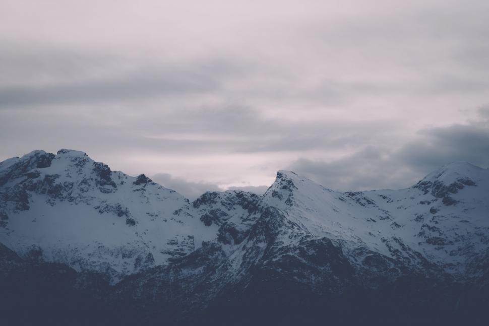 Free Image of Snow Covered Mountain Range Under Cloudy Sky 
