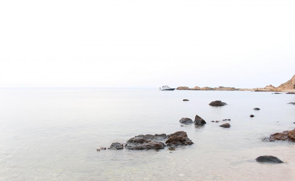 Free Image of Large Body of Water Surrounded by Rocks 